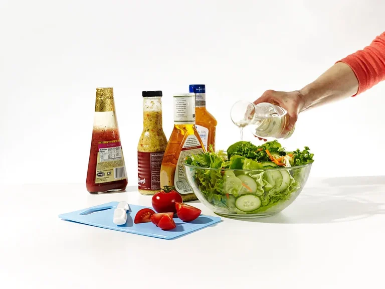 Assortment of homemade salad dressings including vinaigrette, ranch, Caesar, and honey mustard in glass jars with fresh ingredients