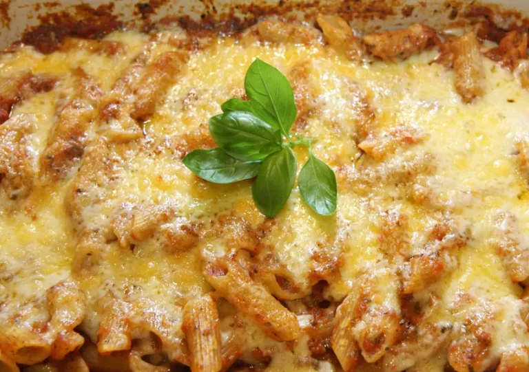 Baked vegan pasta casserole with melted vegan cheese, colorful vegetables, and creamy sauce in a casserole dish