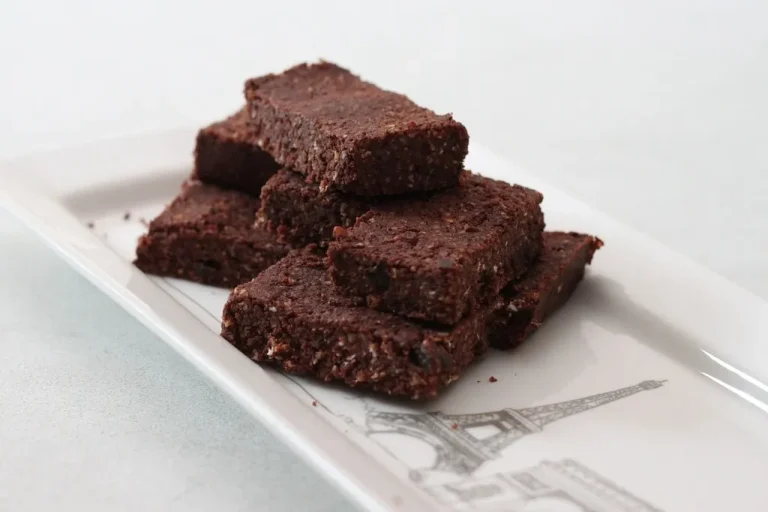 Decadent gooey brownies with a fudgy center, shiny crackly top, and rich chocolate flavor on a serving plate