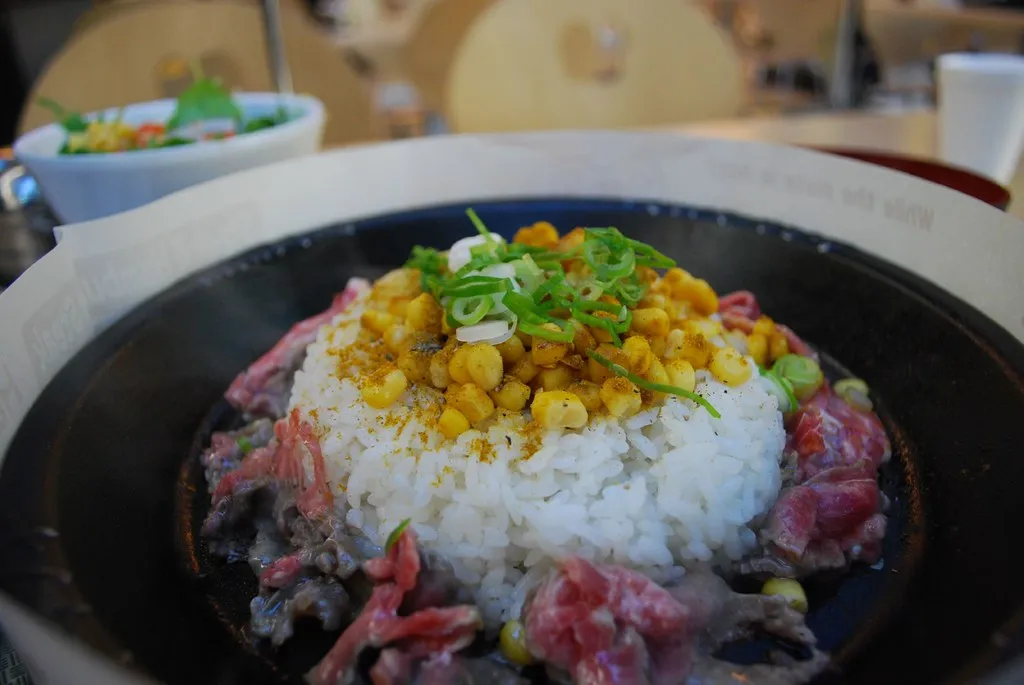 Sizzling Pepper Lunch-style beef pepper rice with garlic butter, corn, and green onions served on a hot cast iron plate.