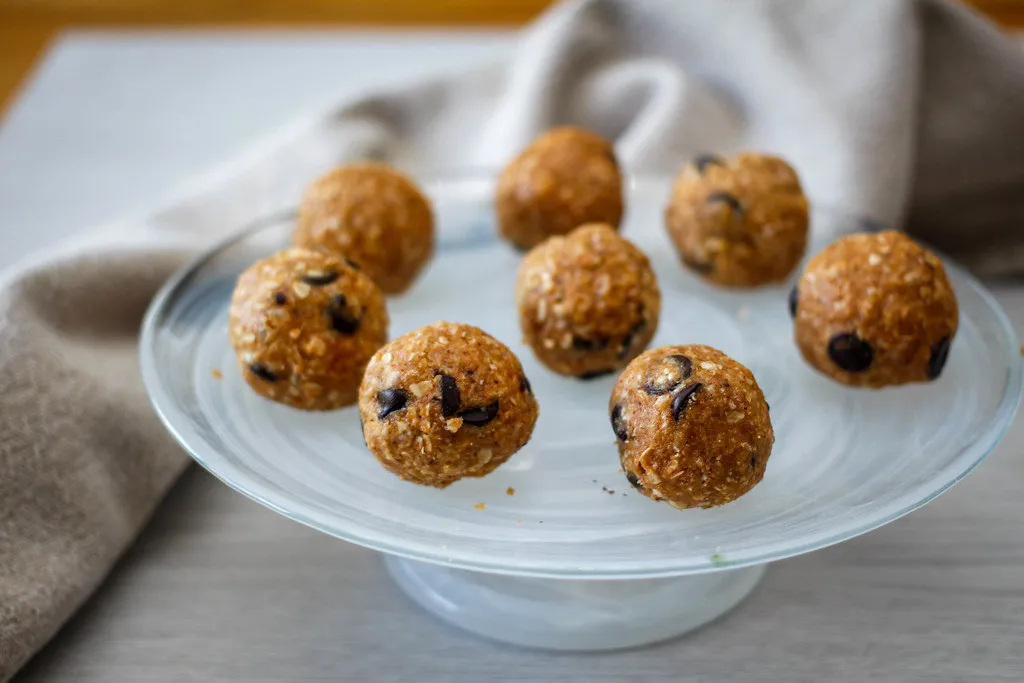 Healthy pumpkin energy bites in a bowl topped with chopped nuts and pumpkin spice