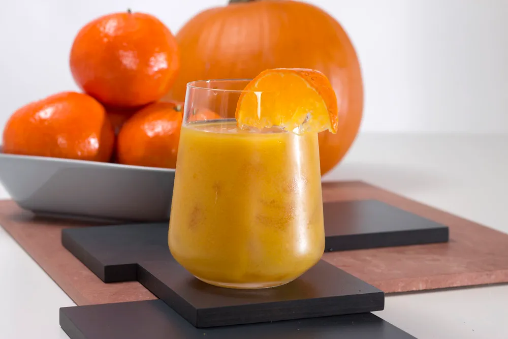 Creamy pumpkin smoothie in a glass garnished with cinnamon and chia seeds