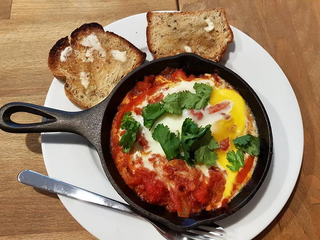 Traditional Arabic shakshuka with eggs poached in tomato sauce served in a skillet