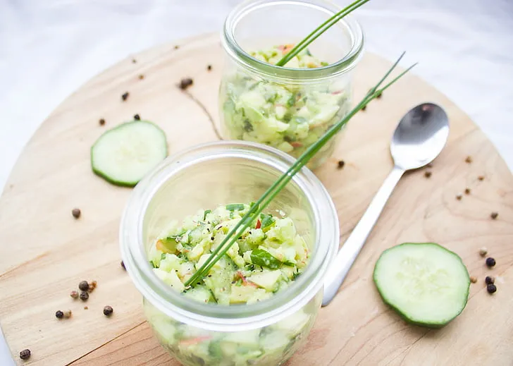 Close-up of creamy cucumber dill salad with thin cucumber slices and chopped dill