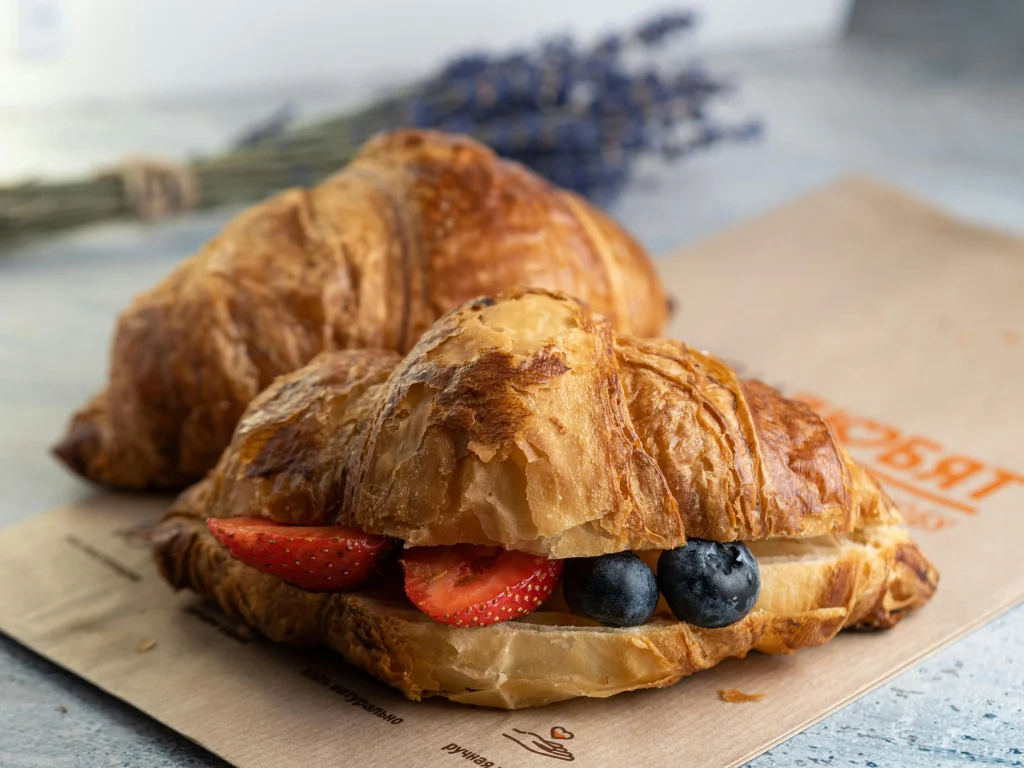 Golden crescent roll breakfast sandwiches served with fresh fruit and herbs