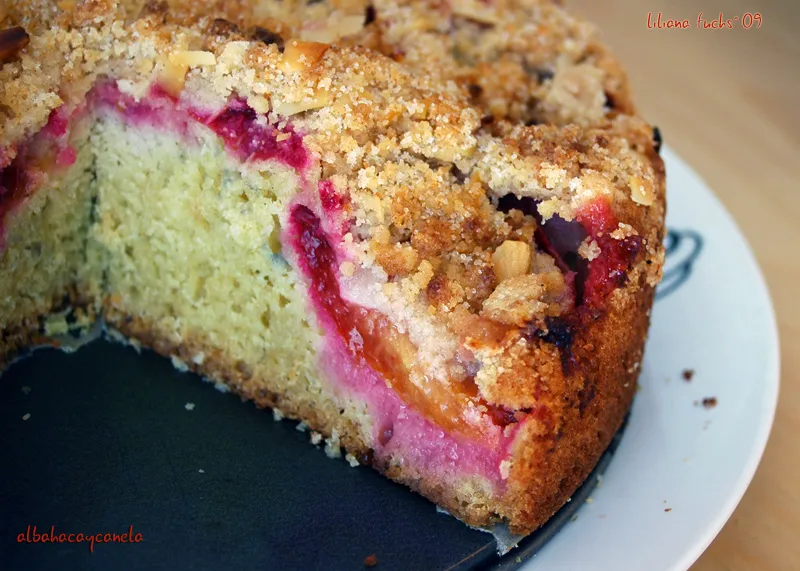 Freshly baked strawberry crumble cake with golden buttery topping on a wooden board