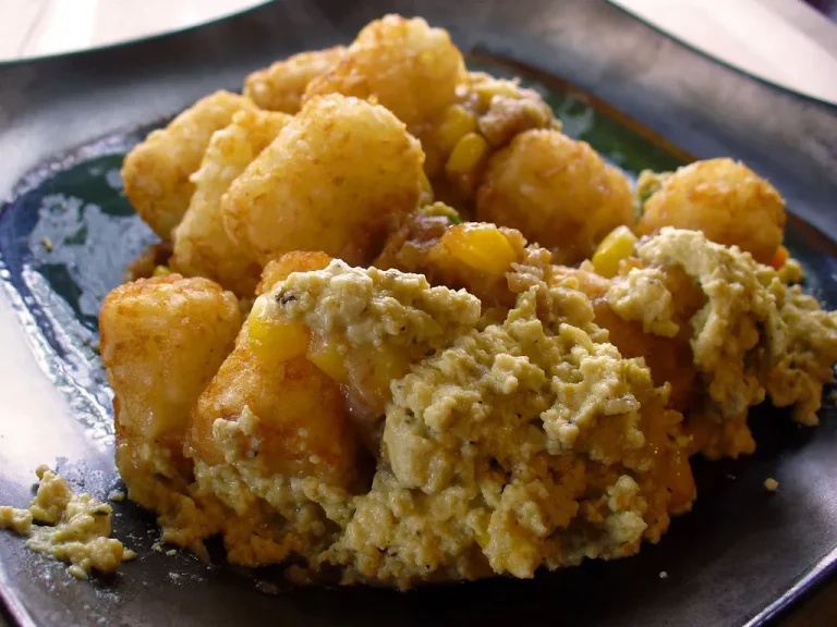 Cheesy tater tot breakfast casserole with sausage, eggs, and melted cheddar baked golden in a 9x13 dish.