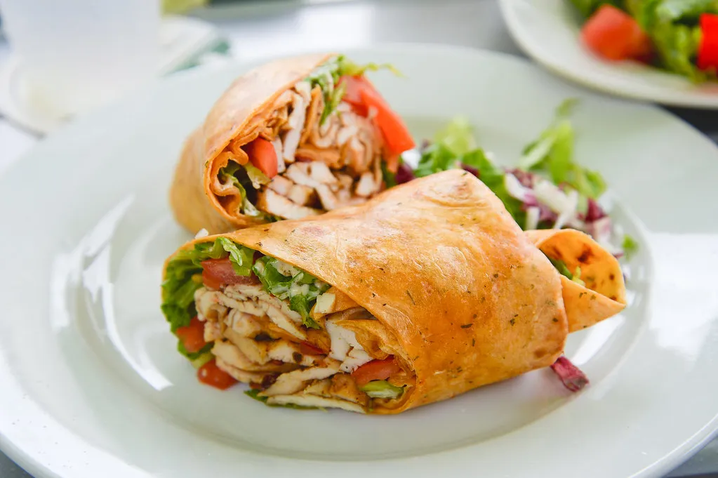 Big Mac tortilla wrap filled with ground beef, lettuce, cheese, and special sauce on a plate.