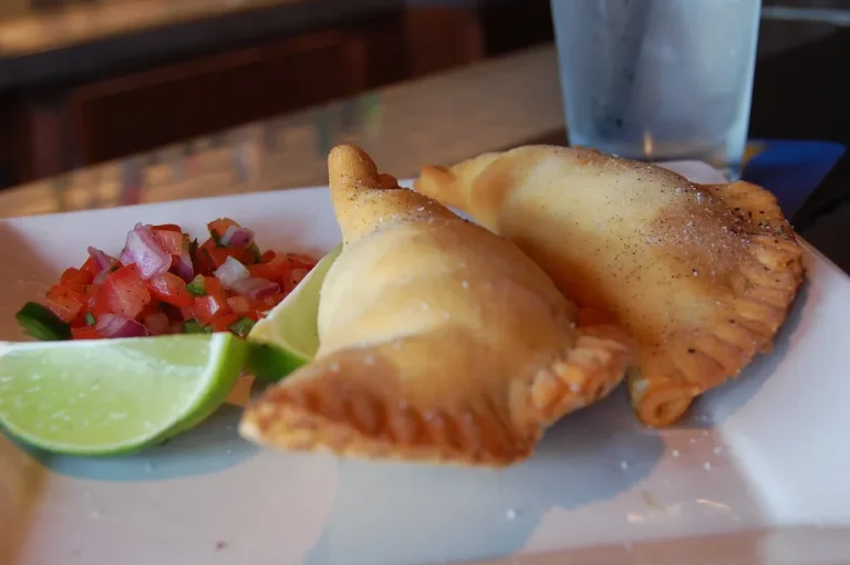 Golden crispy Venezuelan empanadas with guasacaca sauce on the side