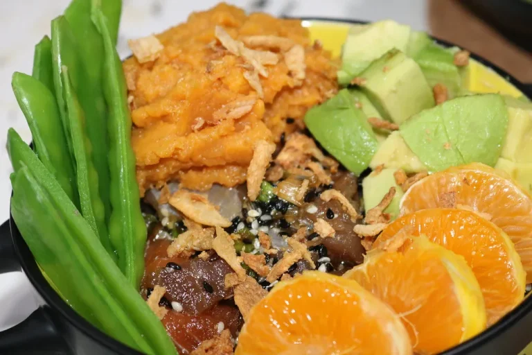 Fresh mandarin orange salad with spinach, almonds, and cranberries in a glass bowl.