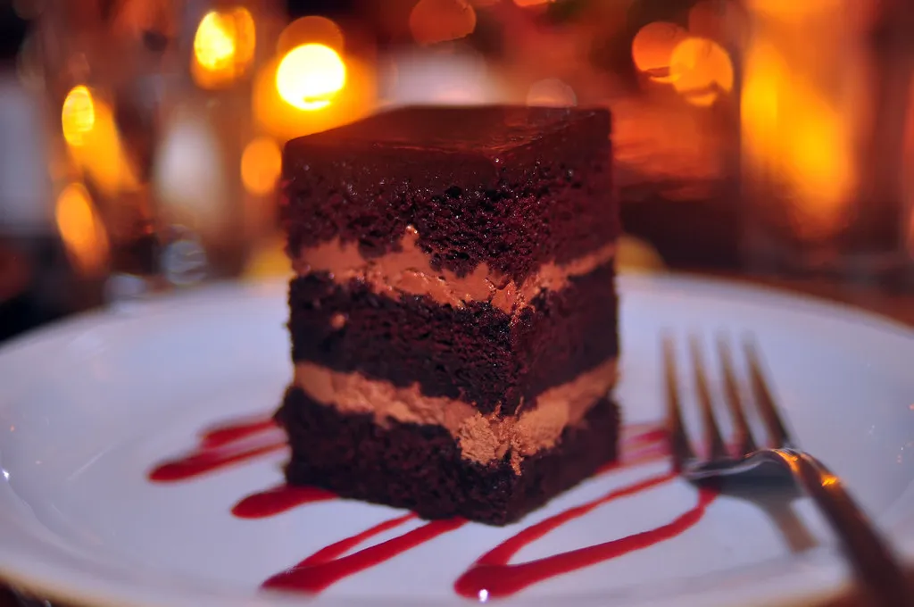 Slice of double chocolate cake with ganache and chocolate shavings
