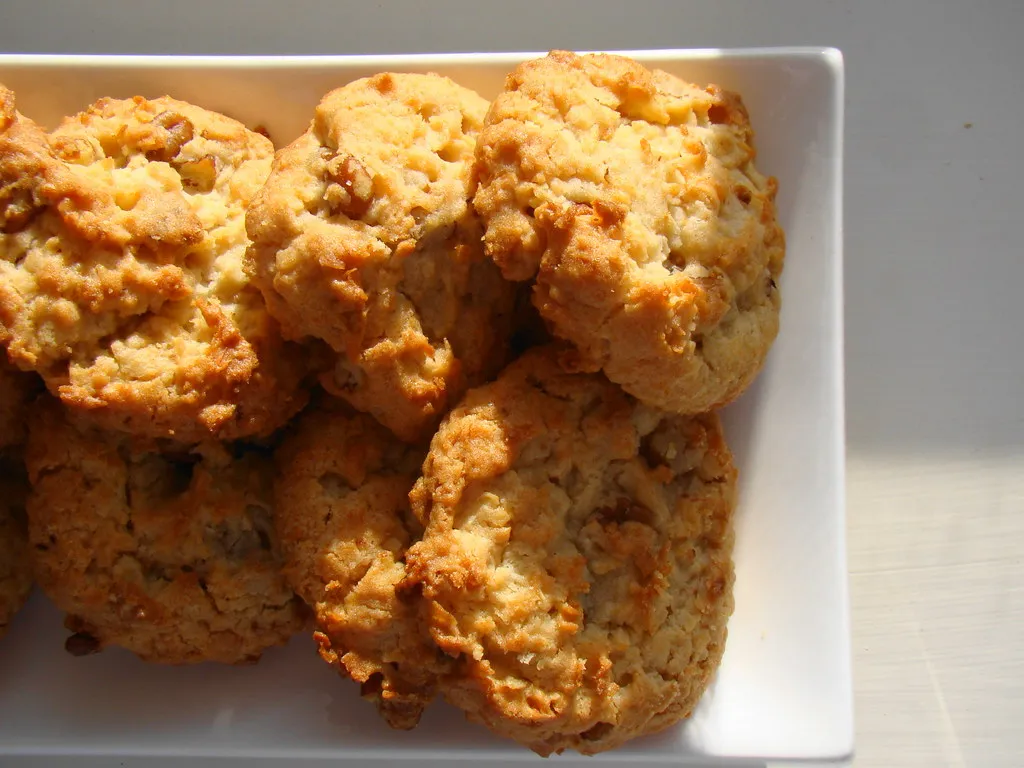Freshly baked coconut pecan cookies on a cooling rack with golden crispy edges