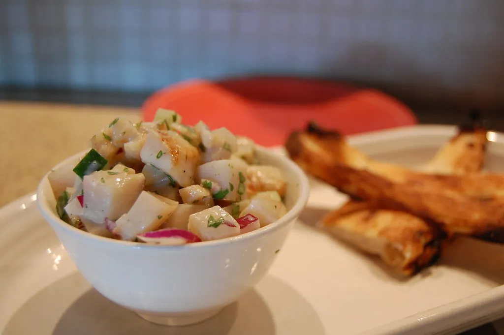 Fresh Bahamian conch salad with lime, peppers, and tomatoes served in a bowl