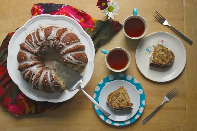 Homemade sour cream coffee cake with streusel topping and a cup of coffee beside it.