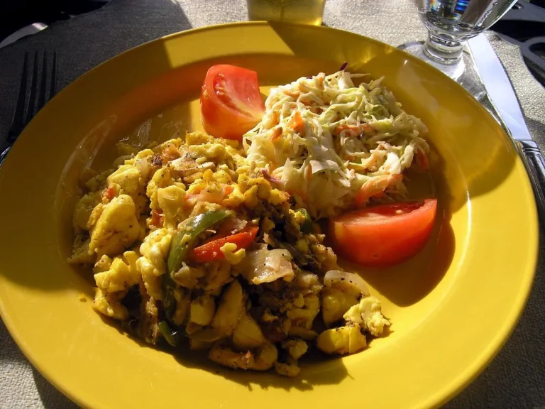 Close-up of ackee and saltfish with onions, peppers, and tomatoes, a classic Jamaican breakfast dish