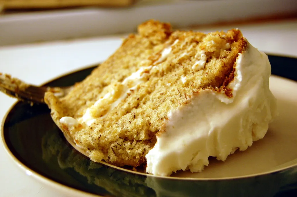 Fluffy banana cream cake with whipped cream frosting and banana slices on top