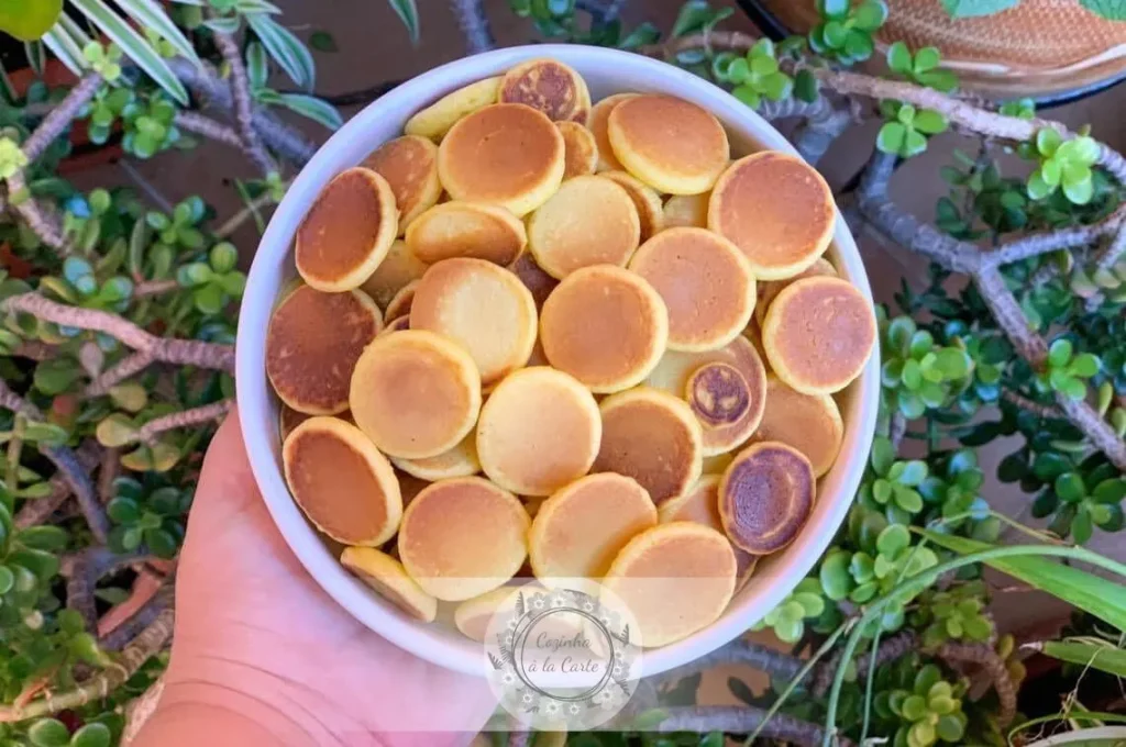 Bowl of golden mini pancake cereal topped with butter and maple syrup, inspired by the viral TikTok recipe