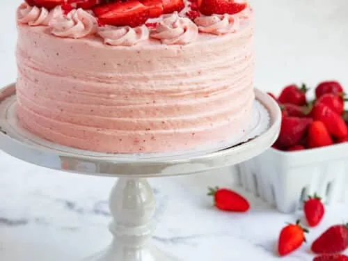Homemade Paula Deen strawberry cake with cream cheese frosting and fresh strawberries on top