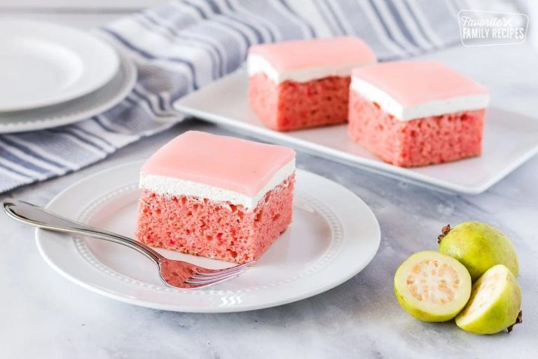 Slice of homemade guava cake with pink guava glaze on a white plate.