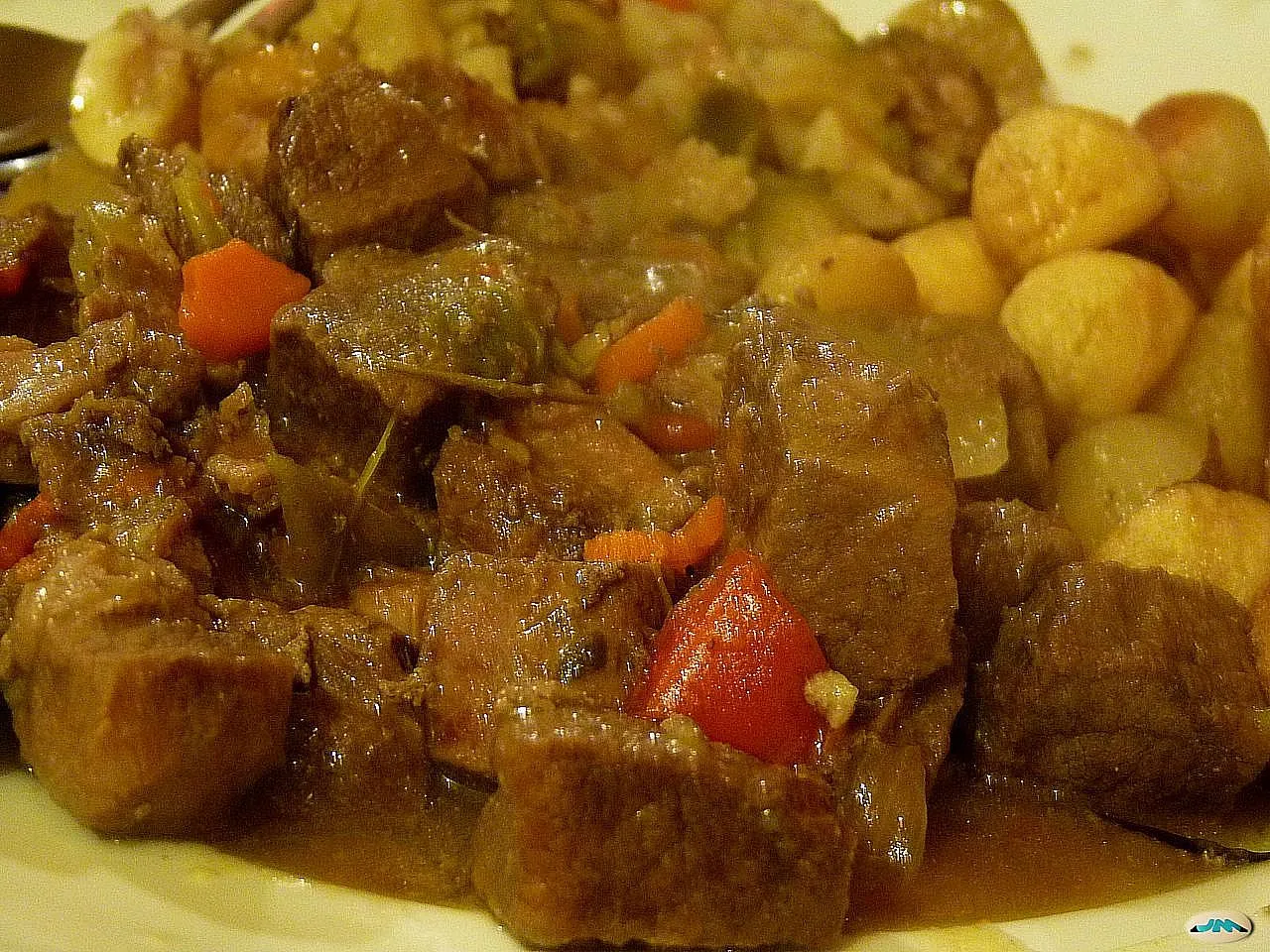 Rich and flavorful Filipino Beef Caldereta served with rice and vegetables in a rustic bowl.