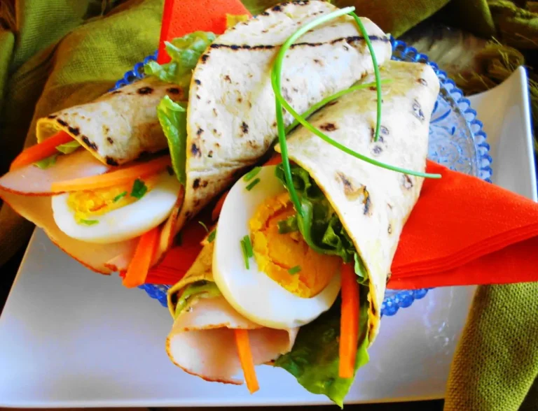 Homemade McDonald’s-style Big Mac wrap sliced in half with pickles and melted cheese inside.