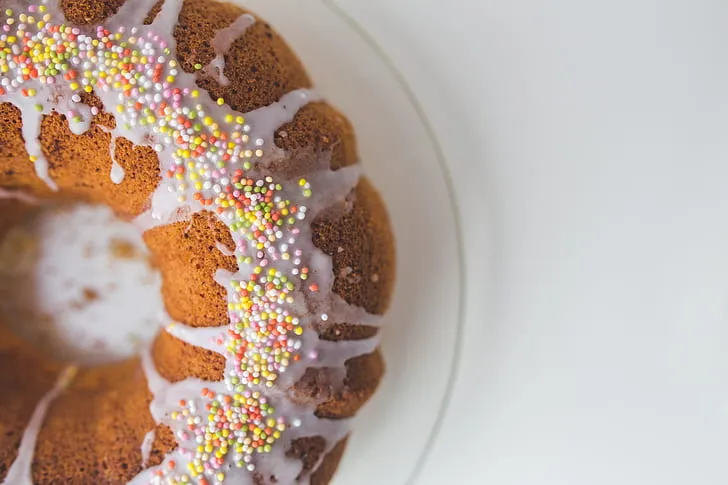 Moist and fluffy carrot bundt cake topped with walnuts and icing drizzle