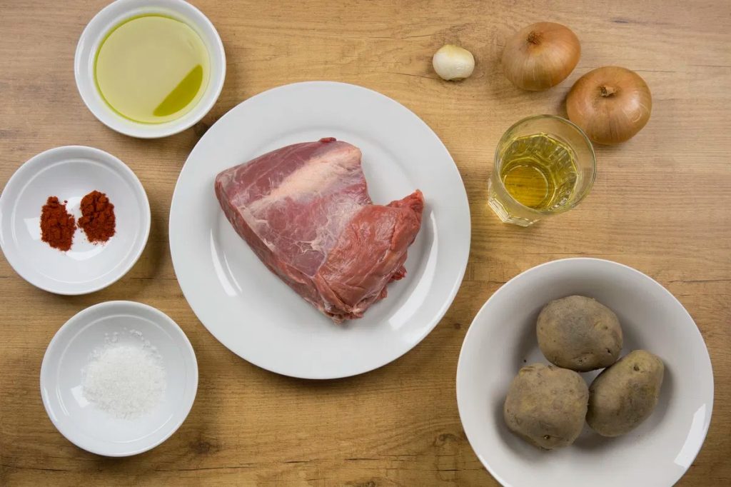 Authentic Cuban Carne con Papas with tender beef and potatoes in a rich tomato sauce, served with rice.