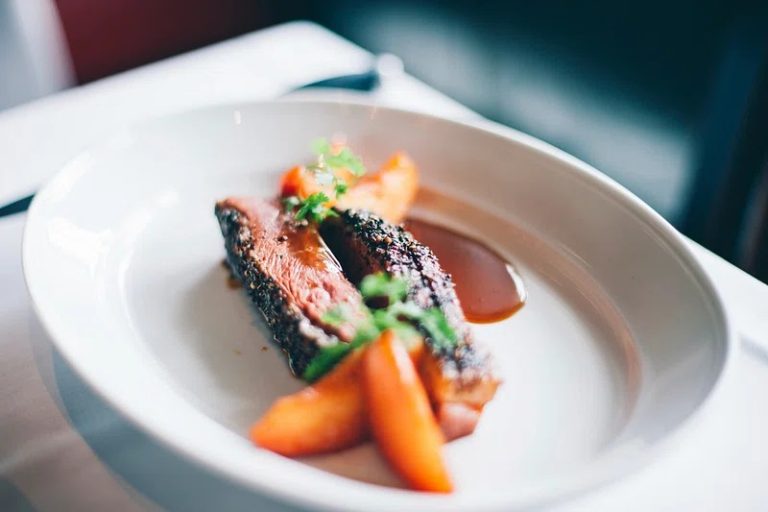 Mediterranean-style branzino fillet garnished with parsley, lemon slices, and olive oil for an elegant gourmet dinner presentation.
