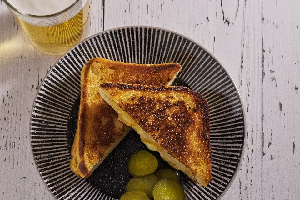 A delicious spread of sourdough breakfast recipes including pancakes, waffles, and a savory egg sandwich on a rustic wooden table.