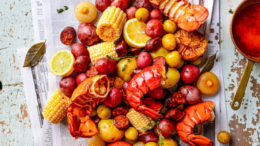 Freshly cooked shrimp, mussels, and scallops on a platter with lemon wedges and herbs, representing quick and tasty sea fruits recipes.