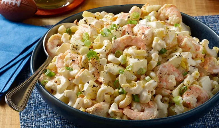 Cold pasta salad with shrimp, celery, and mayonnaise dressing garnished with parsley