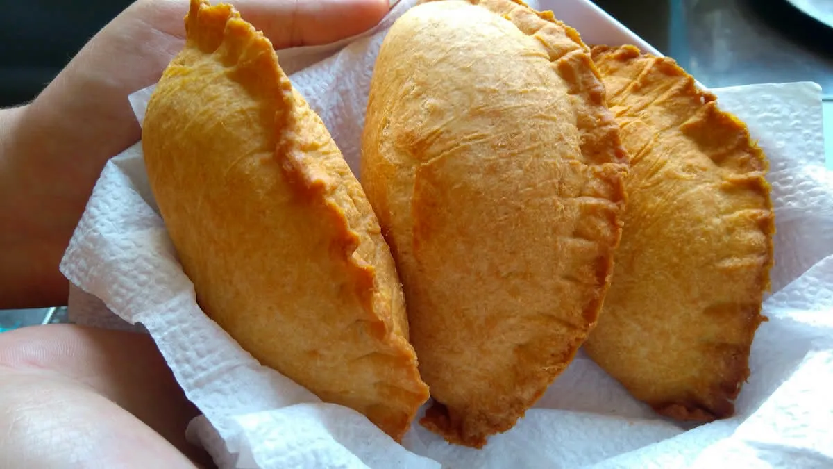 Golden crispy Venezuelan empanadas with guasacaca sauce on the side
