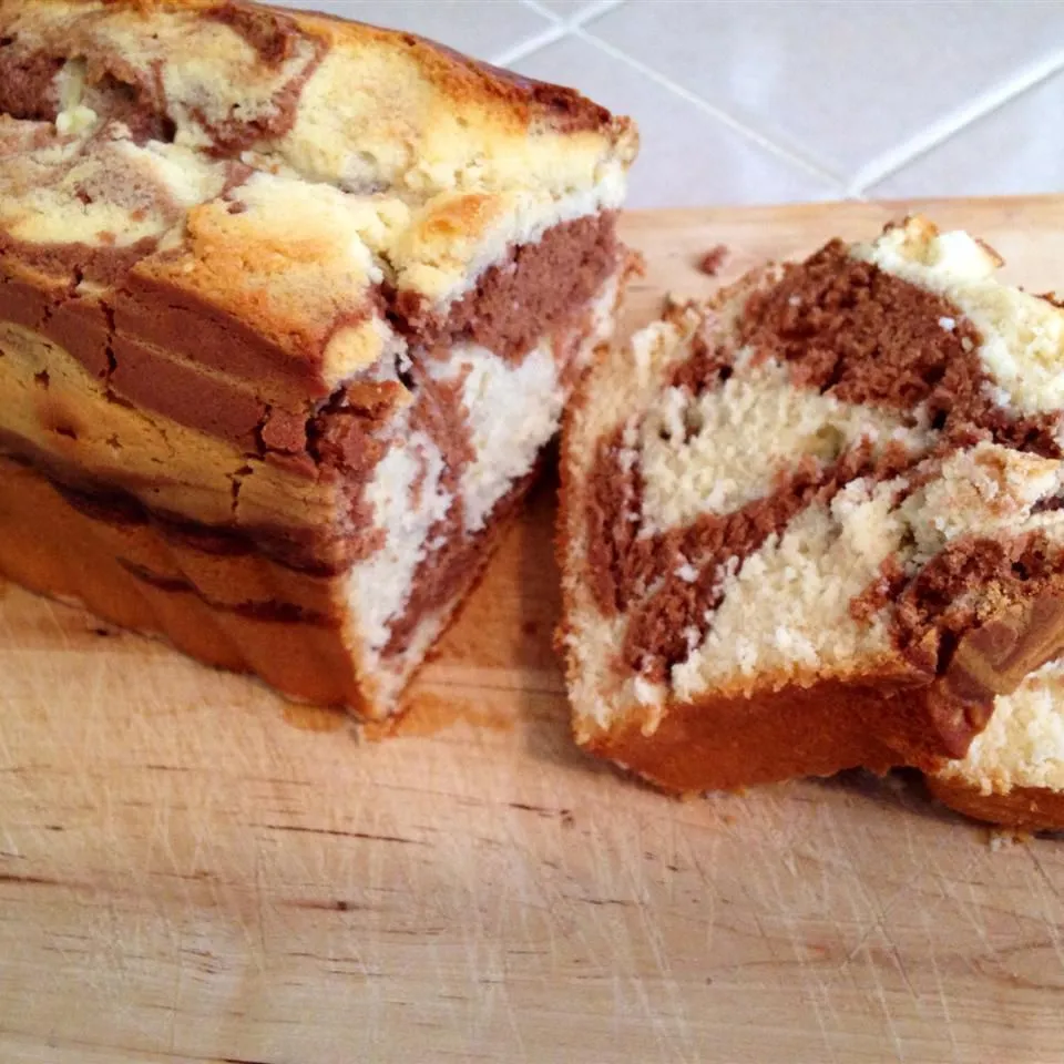Moist and tender marble pound cake with rich chocolate and vanilla swirls on a serving plate.