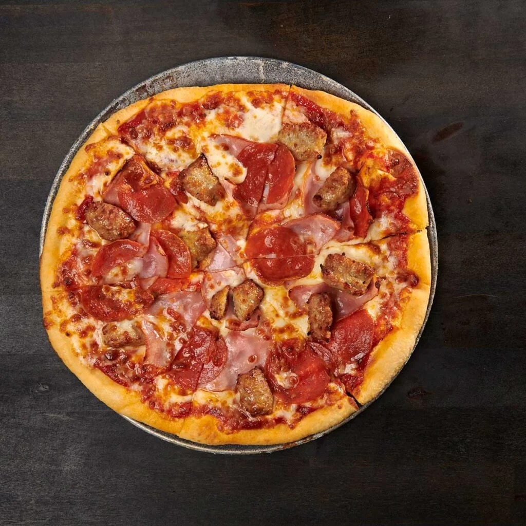 Homemade Blackstone pizza with crispy golden crust and melted mozzarella cheese on outdoor griddle