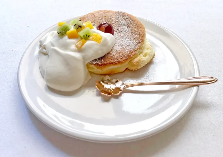 Soft, jiggly Japanese soufflé pancakes on a plate with syrup