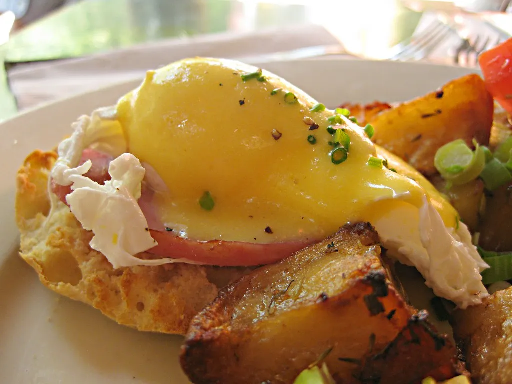 Classic Eggs Benedict with poached eggs, Canadian bacon, and creamy hollandaise sauce on toasted English muffins