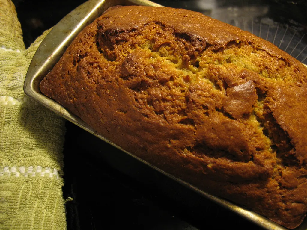 Freshly baked banana bread loaf cooling on a wire rack, golden brown and soft inside