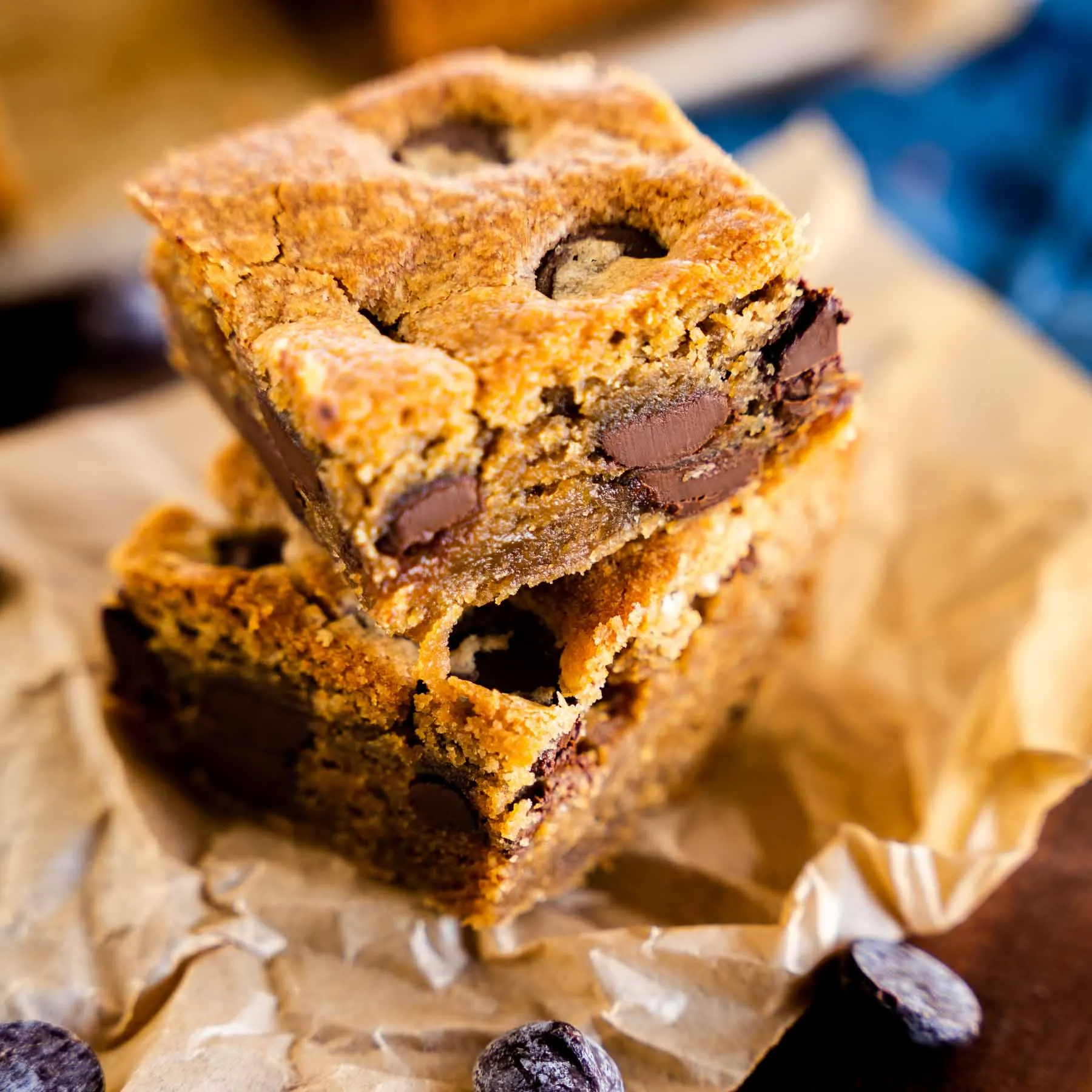Close-up of soft, chewy peanut butter blondies with chocolate chips on a rustic plate