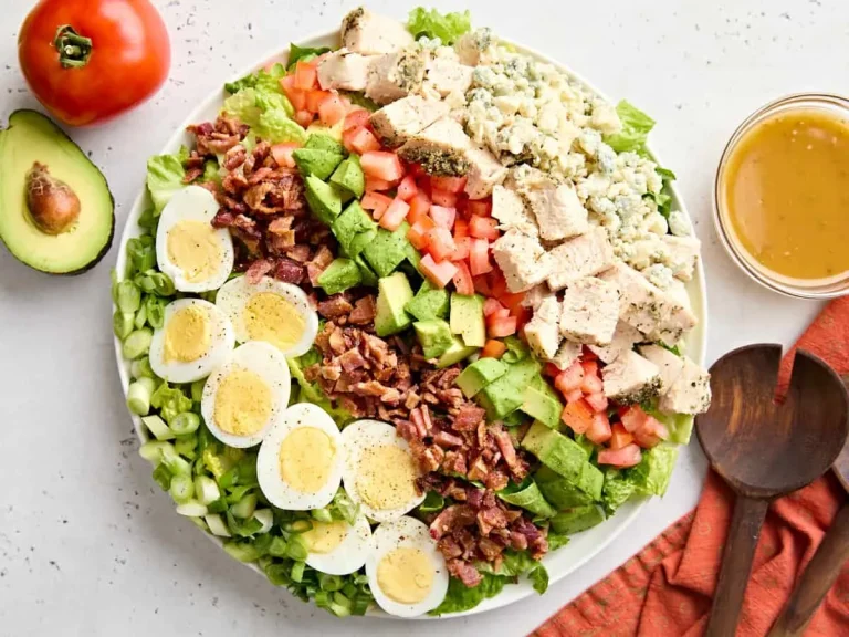 Fresh and colorful Cobb salad served in a bowl, garnished with herbs and dressing
