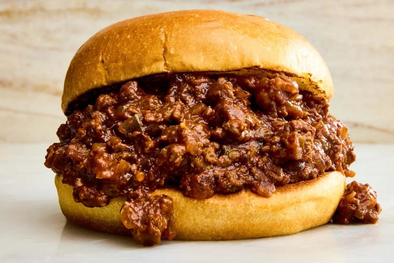 Classic American Sloppy Joes served with melted cheddar and fresh vegetables, ready to eat