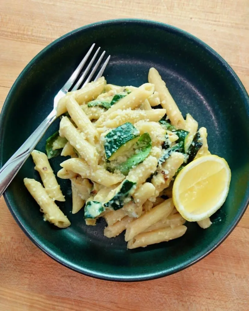 Creamy ricotta pasta with lemon zest, garlic, parmesan, and fresh basil in a white bowl